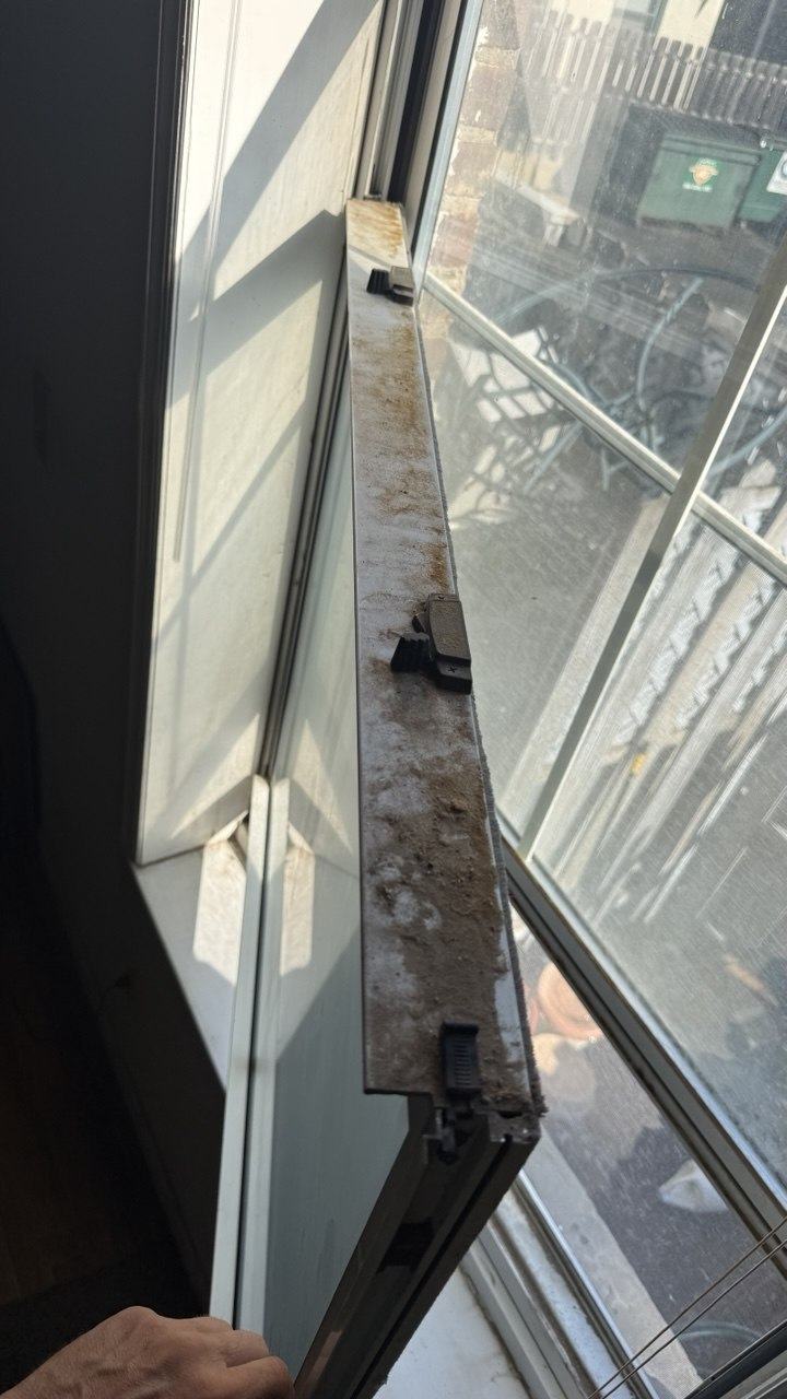 Technician handling a large glass pane at the window opening during installation